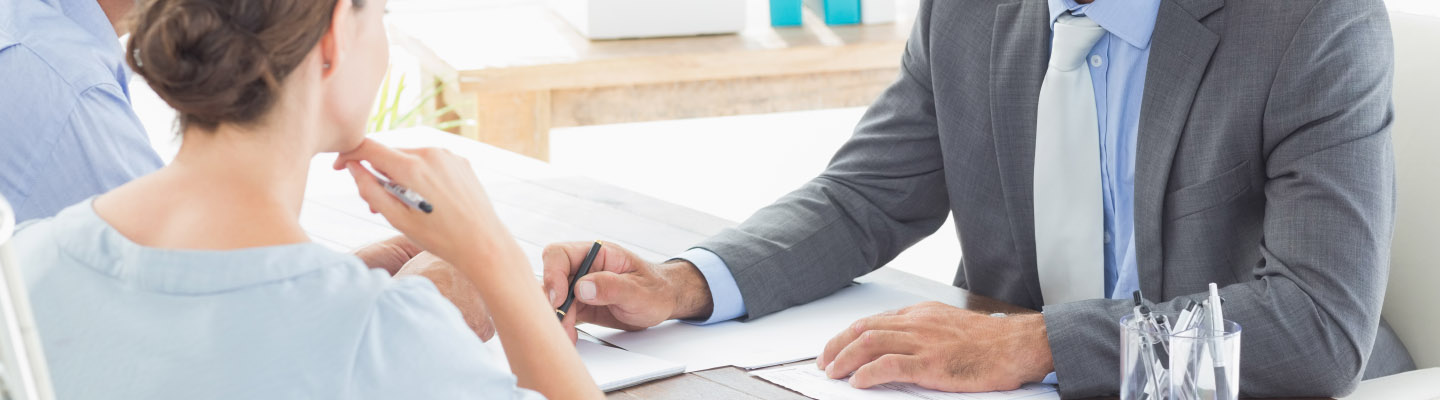 man meeting with a couple going over paperwork