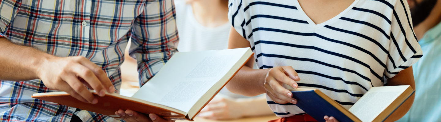 Two people looking at open textbooks.