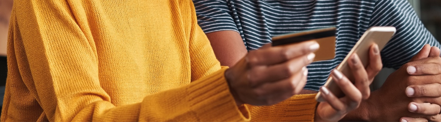 Person holding phone and credit card